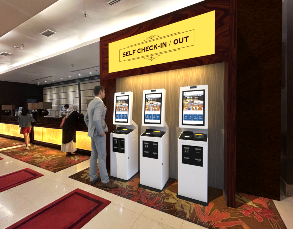 Three self-service kiosks beneath a "Self Check-In / Out" sign in a hotel lobby