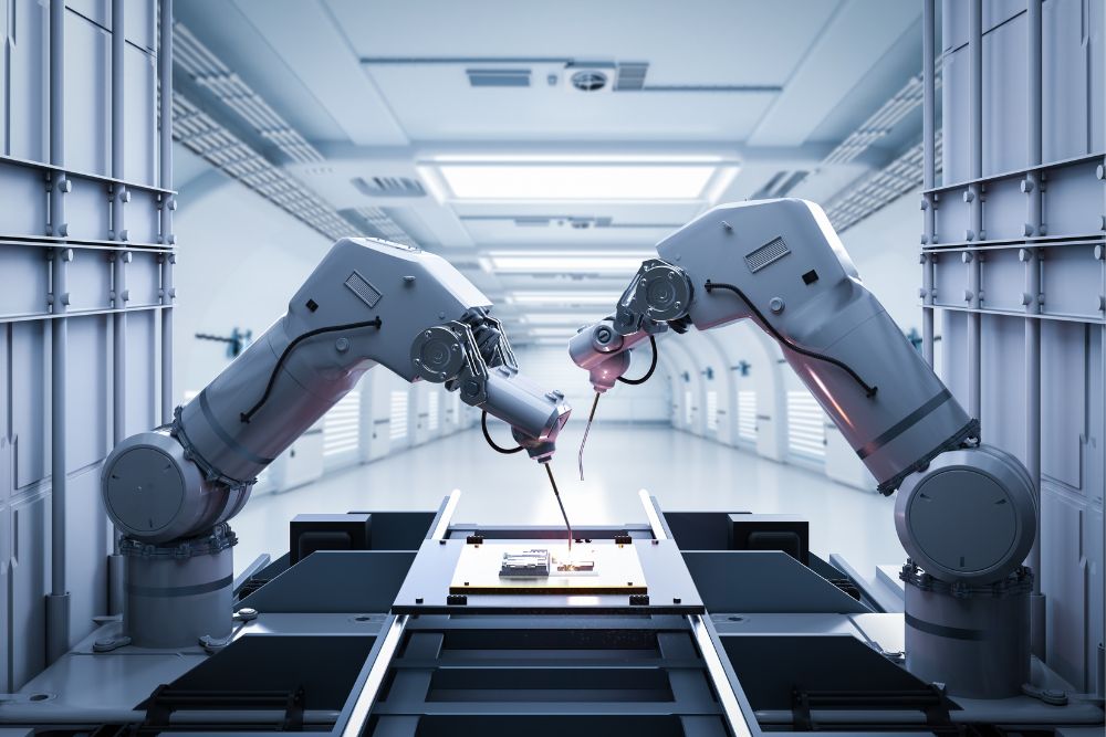 Two robotic arms assembling components over a conveyor in a clean production facility