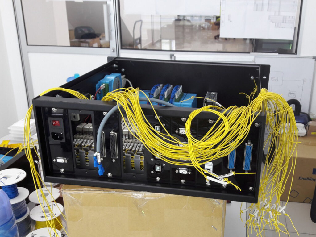 An open rackmount industrial PC chassis showing internal cards and bundled yellow wiring